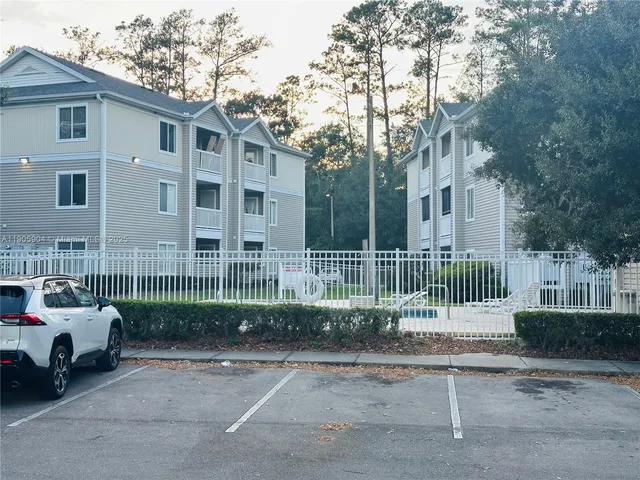 a view of a brick house with a small yard plants and trees