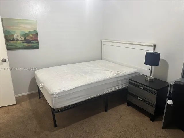 a bedroom with a bed and lamp on table