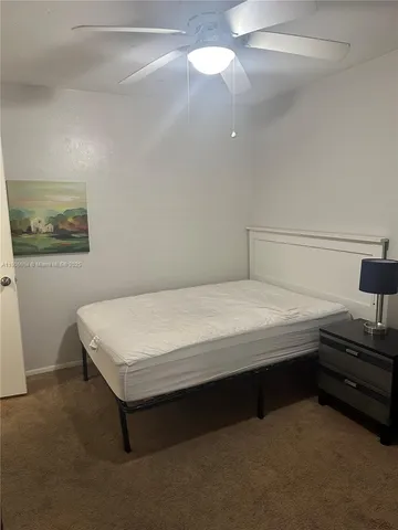 a bedroom with a bed and a chandelier fan