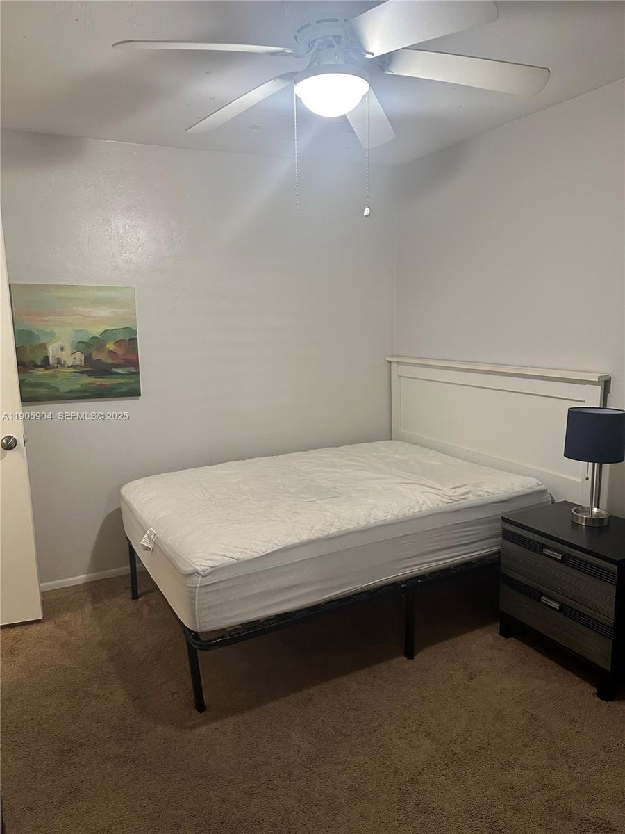 4000 Southwest 23rd Street, Unit 2301 Gainesville, FL 32608 - Photo 10 of 19 a bedroom with a bed and a chandelier fan