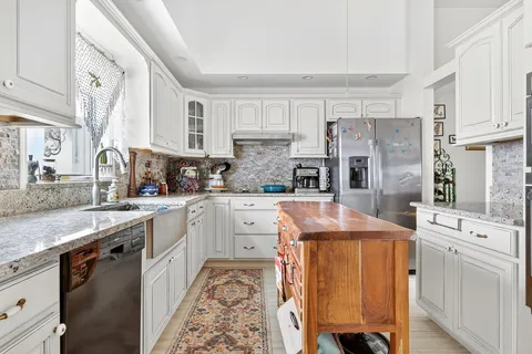 a kitchen with stainless steel appliances kitchen island granite countertop a sink and cabinets