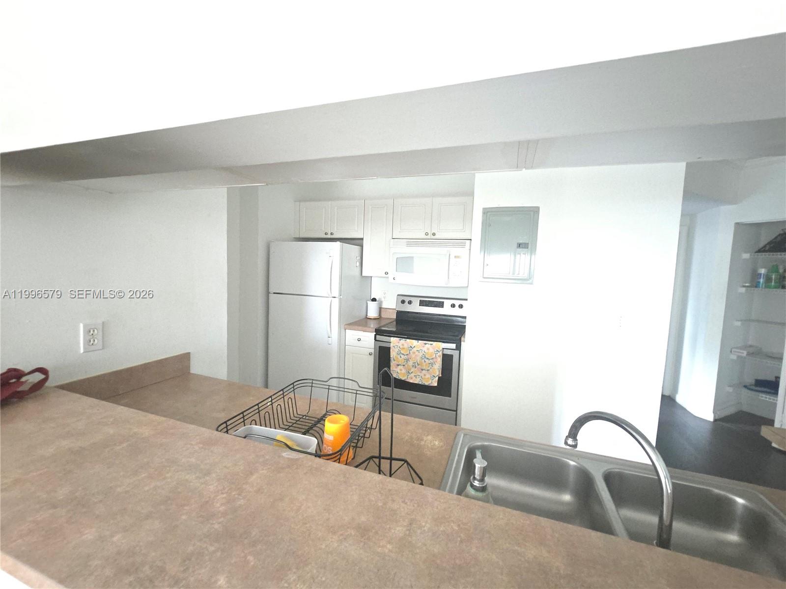 17150 North Bay Road, Unit 2316 Sunny Isles Beach, FL 33160 - Photo 3 of 9 a kitchen with granite countertop a refrigerator and a sink