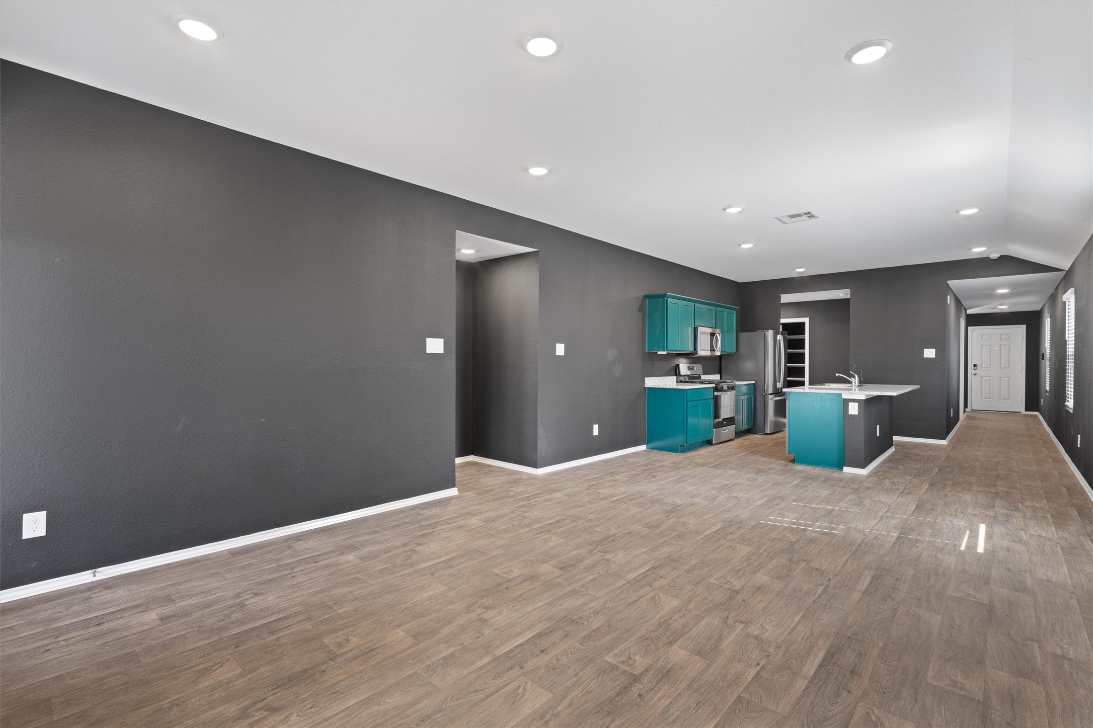 352 Sickle Loop Uhland, TX 78640 - Photo 16 of 36 Open-concept living area with recessed lighting and view toward kitchen and entry.