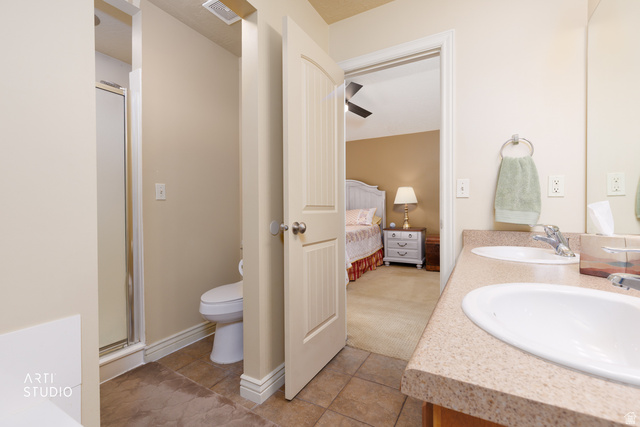 6761 950 East Midvale, UT 84047 - Photo 23 of 44 Bathroom featuring a dual vanity with light-toned countertops, a shower with a glass enclosure, a toilet, and tiled flooring