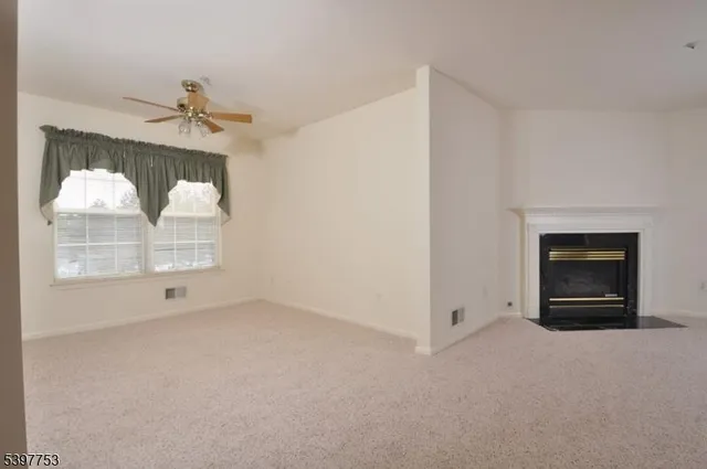 a view of an empty room with a fireplace and a window