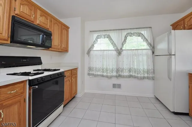 a kitchen with a stove a microwave and white cabinets