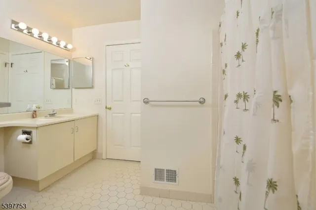 a bathroom with a double vanity sink mirror and shower