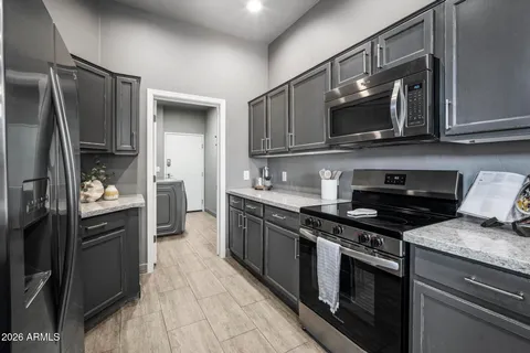 a kitchen with stainless steel appliances granite countertop a stove microwave and refrigerator
