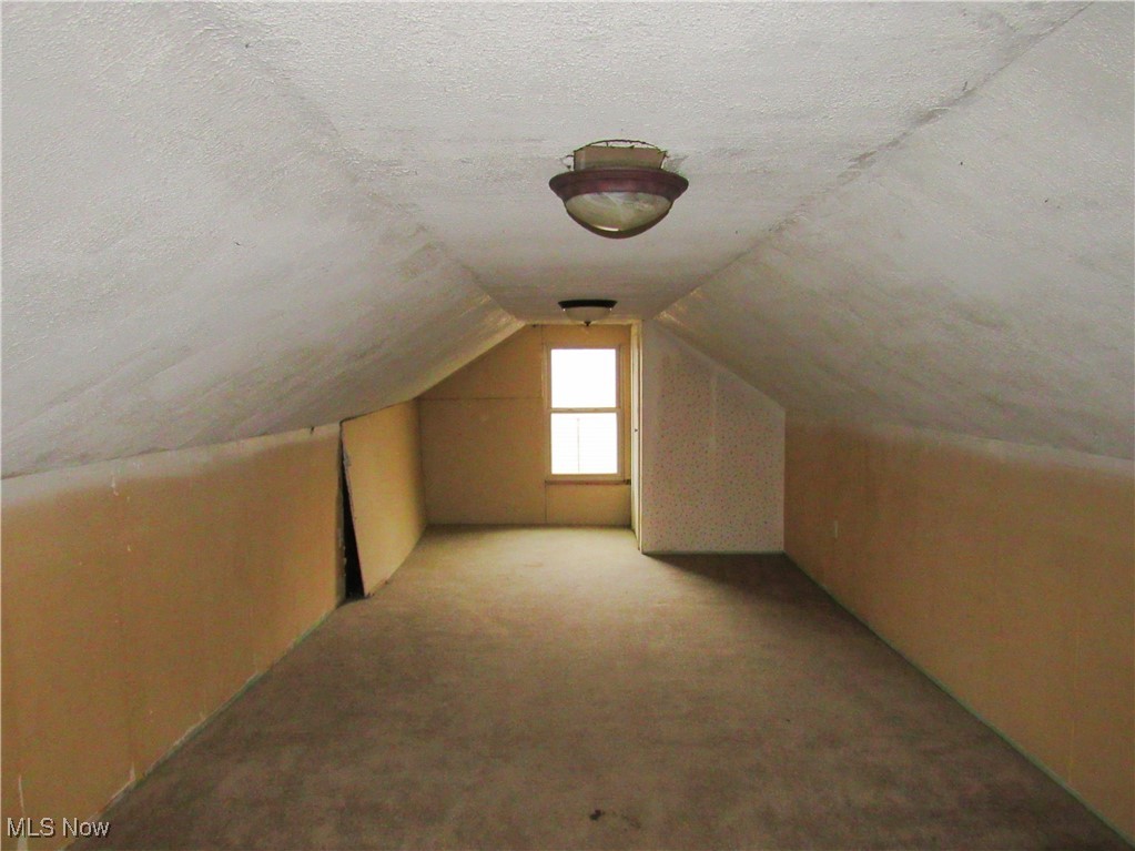 2218 Lake Road Akron, OH 44312 - Photo 15 of 20 Additional living space featuring lofted ceiling, a textured ceiling, and carpet