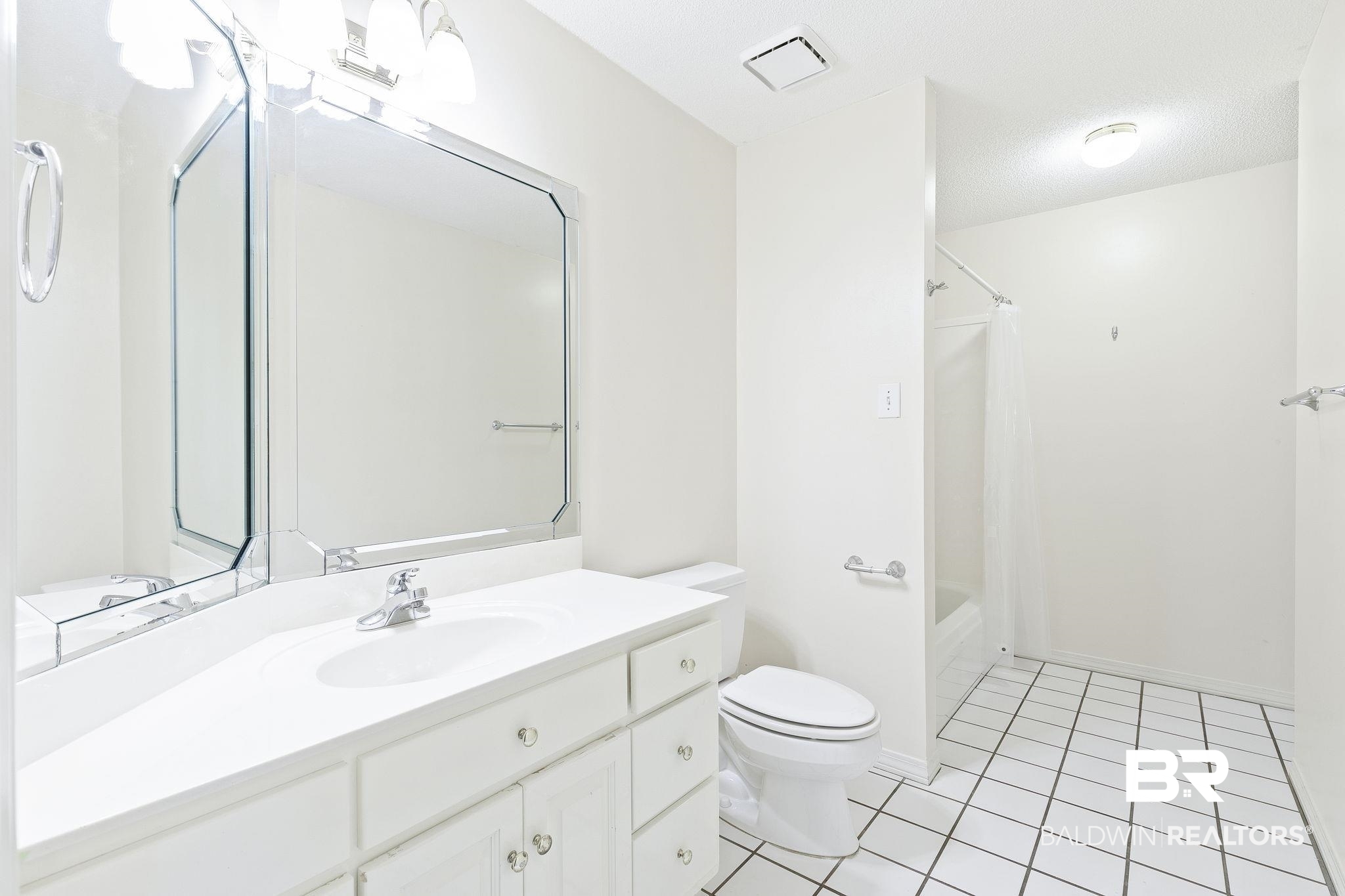 2100 Stonebrook Drive West Mobile, AL 36695 - Photo 36 of 60 Full bathroom with shower / bathtub combination with curtain, tile patterned floors, a textured ceiling, toilet, and vanity