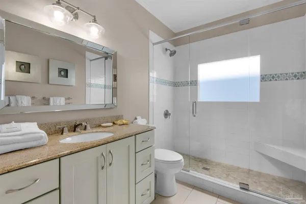 a bathroom with a granite countertop sink a toilet and a mirror