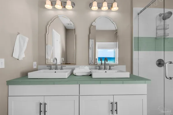 a bathroom with double vanity sinks and a mirror