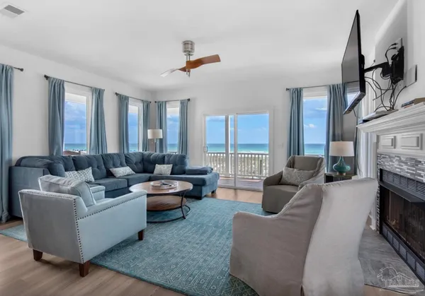 a living room with fireplace furniture and a large window