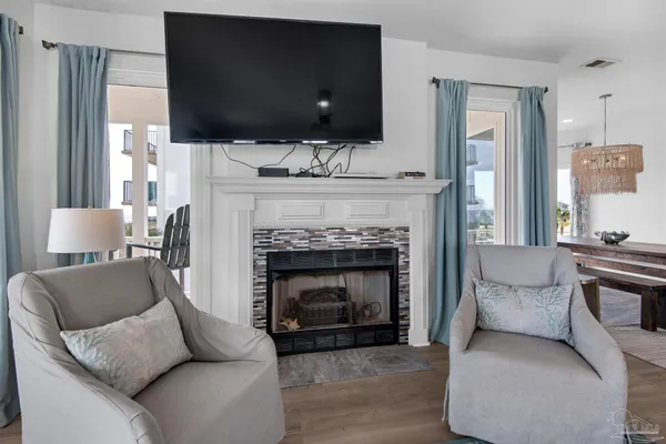 a living room with furniture a flat screen tv and a fireplace