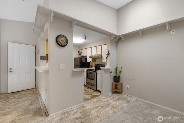 a view of a kitchen with a refrigerator and a stove top oven