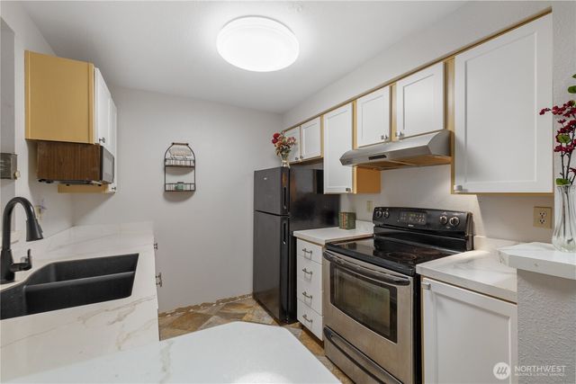 a kitchen with stainless steel appliances a stove a sink and a microwave