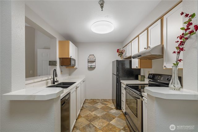 a kitchen with stainless steel appliances a sink stove and refrigerator