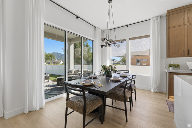 2559 West Aurora Avenue Mapleton, UT 84664 - Photo 11 of 60 Open-concept dining area featuring light wood-finish flooring and a contemporary chandelier