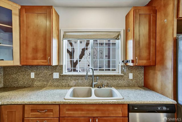 a kitchen with sink a window and cabinets
