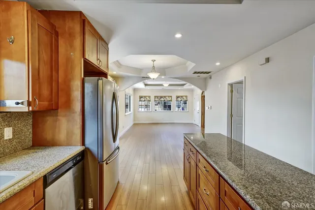 a view of a kitchen with a sink stainless steel appliances wooden floor and a counter top space