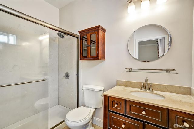 a bathroom with a granite countertop toilet sink and mirror