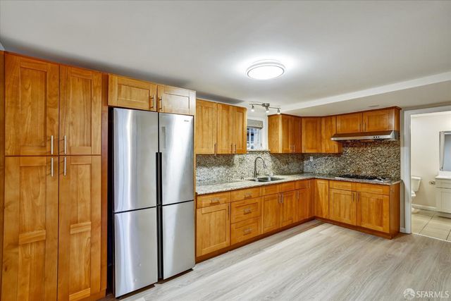 a kitchen with stainless steel appliances granite countertop a refrigerator sink and cabinets
