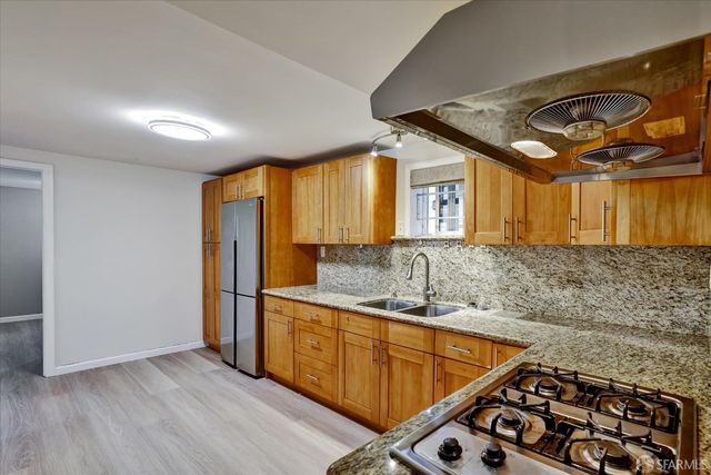 a kitchen with stainless steel appliances granite countertop a sink and a cabinets
