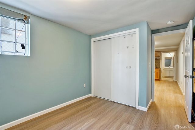 an empty room with wooden floor and a bathroom
