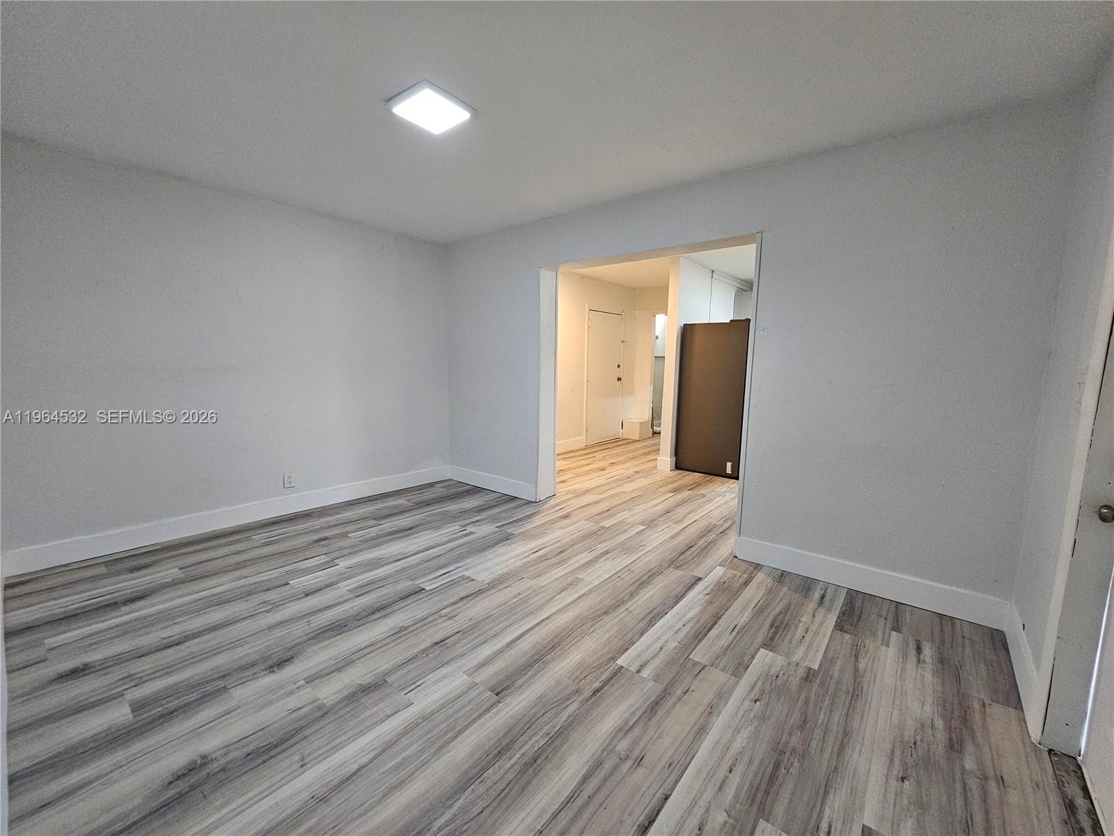 1727 Fletcher Street, Unit 1 Hollywood, FL 33020 - Photo 1 of 31 wooden floor in an empty room with a window