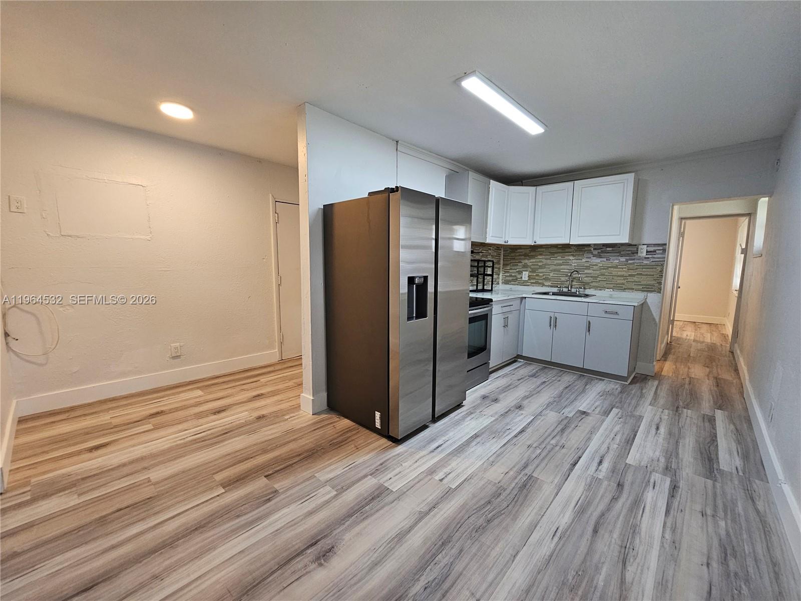 1727 Fletcher Street, Unit 1 Hollywood, FL 33020 - Photo 11 of 31 a kitchen with stainless steel appliances granite countertop a refrigerator and a stove top oven