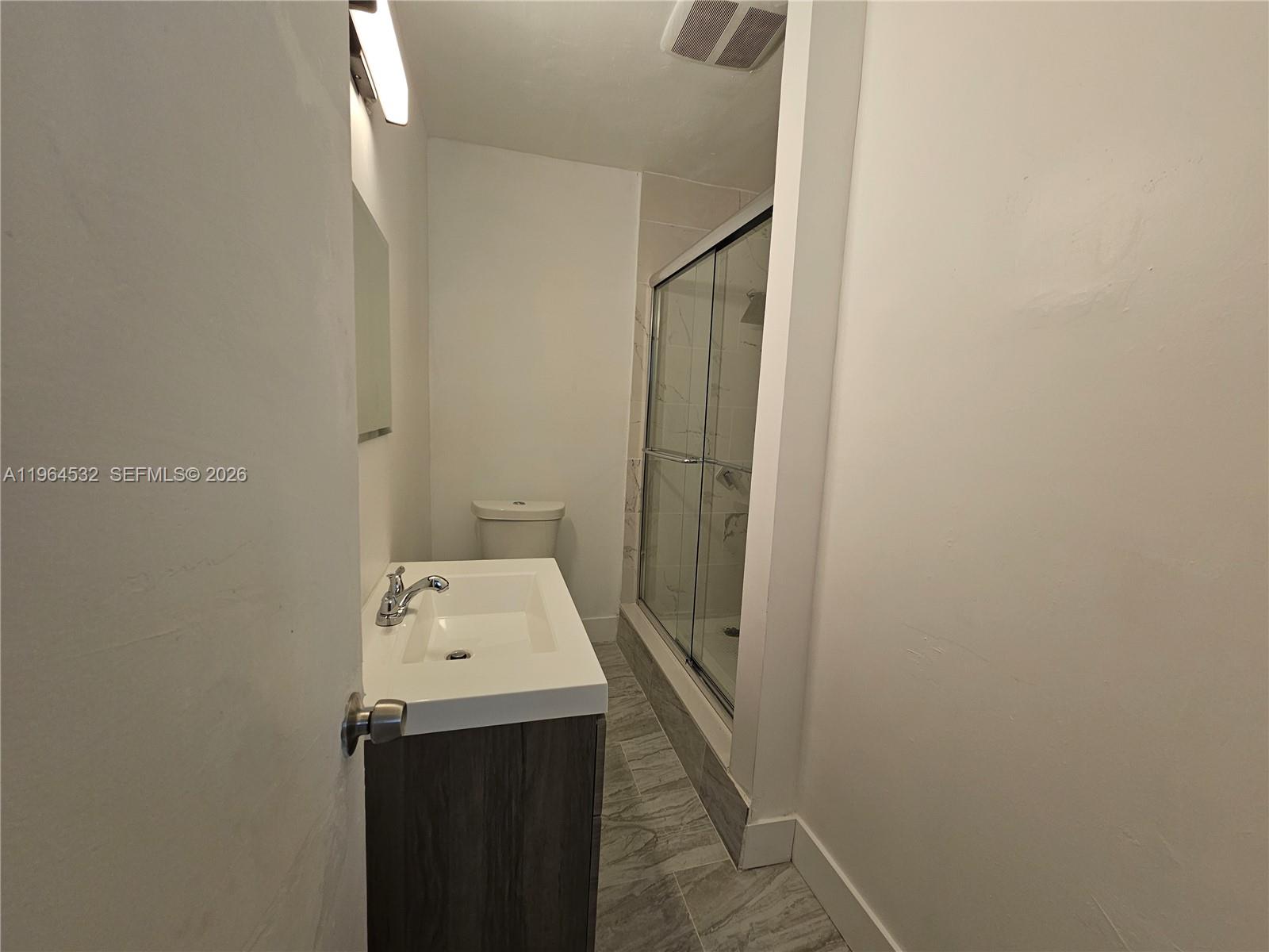 1727 Fletcher Street, Unit 1 Hollywood, FL 33020 - Photo 18 of 31 a bathroom with a sink and mirror with shower