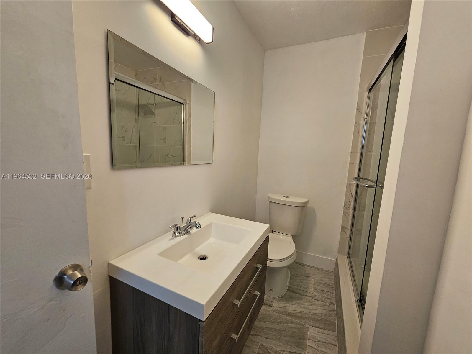 1727 Fletcher Street, Unit 1 Hollywood, FL 33020 - Photo 19 of 31 a bathroom with a sink a toilet a mirror and shower