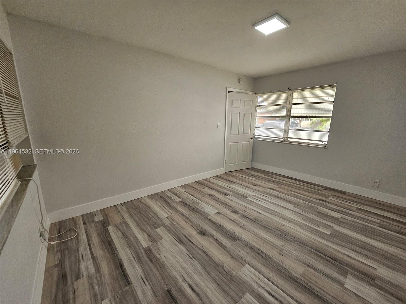 1727 Fletcher Street, Unit 1 Hollywood, FL 33020 - Photo 28 of 31 an empty room with wooden floor and windows