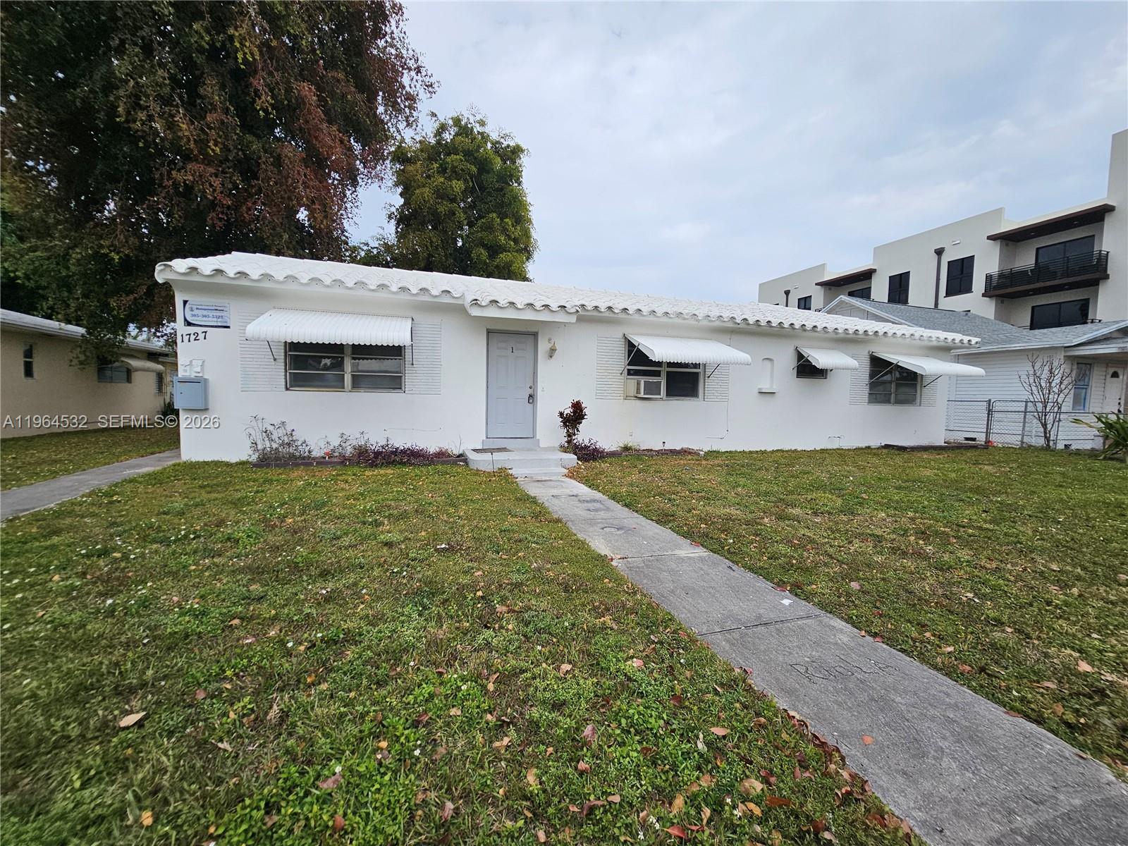 1727 Fletcher Street, Unit 1 Hollywood, FL 33020 - Photo 29 of 31 a view of a white house with a big yard and large trees