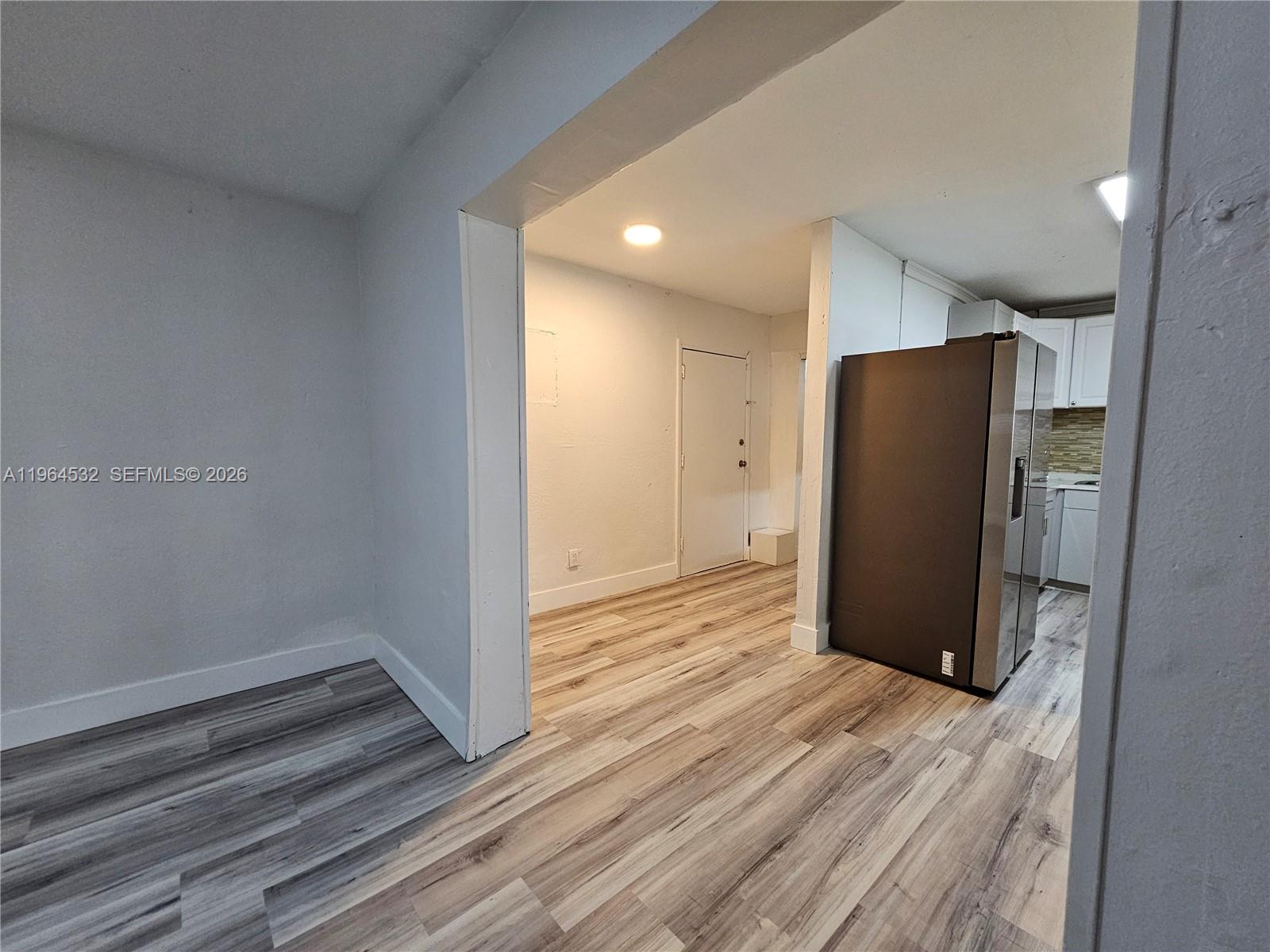 1727 Fletcher Street, Unit 1 Hollywood, FL 33020 - Photo 5 of 31 a view of an empty room with wooden floor and a window