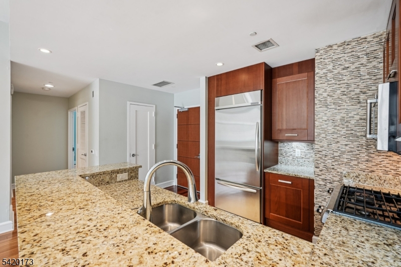 8100 River Road, Unit 210 North Bergen, NJ 07047 - Photo 7 of 25 a kitchen with stainless steel appliances kitchen island granite countertop a sink and cabinets