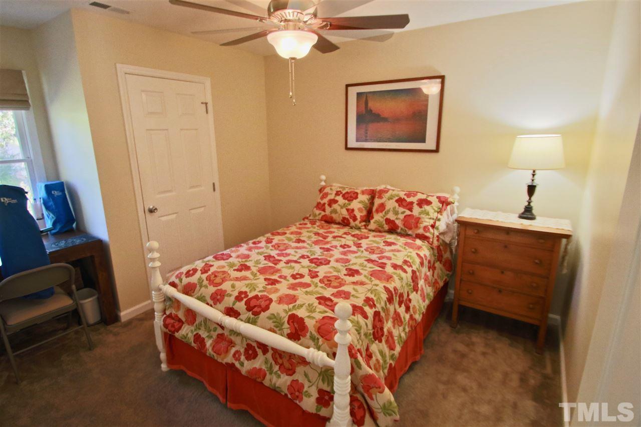 2349 Declaration Drive Raleigh, NC 27615 - Photo 22 of 25 a bedroom with a bed and a chandelier