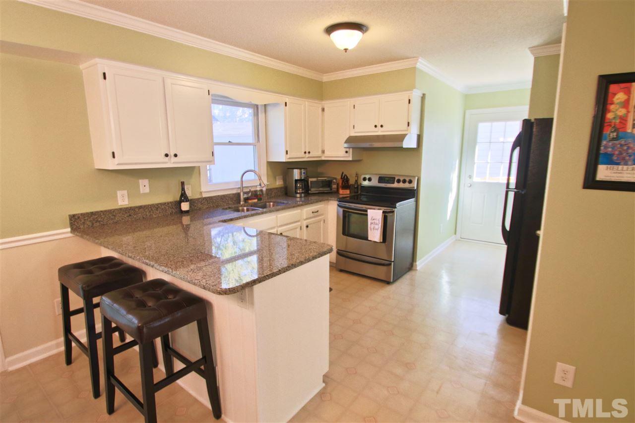 2349 Declaration Drive Raleigh, NC 27615 - Photo 9 of 25 a kitchen with stainless steel appliances granite countertop a stove refrigerator sink and cabinets