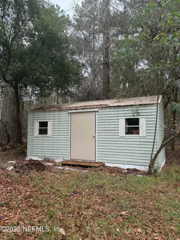 a backyard of a house with lots of green space and trees all around