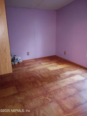 a view of an empty room with a kitchen