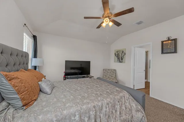 a bedroom with a large bed and a tv