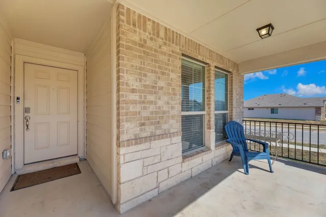 a view of a balcony with furniture and next to a window