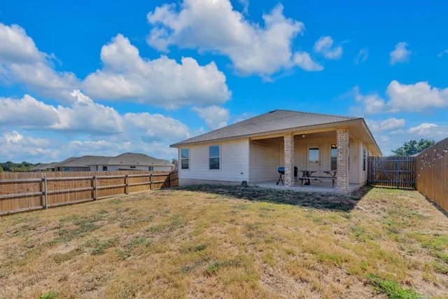 a view of a house with backyard and sitting area