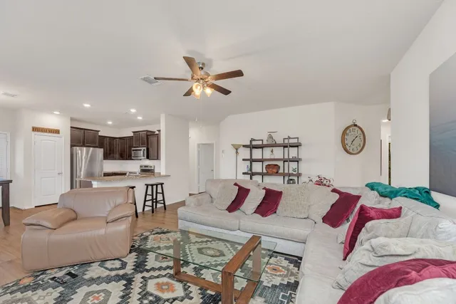 a living room with furniture and view of kitchen
