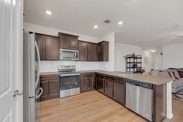 a kitchen with stainless steel appliances granite countertop a sink stove and refrigerator