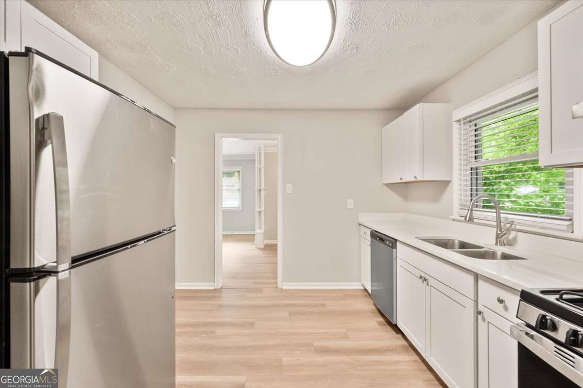 752 Jefferson Avenue Southwest Atlanta, GA 30315 - Photo 8 of 30 a kitchen with white cabinets and a refrigerator