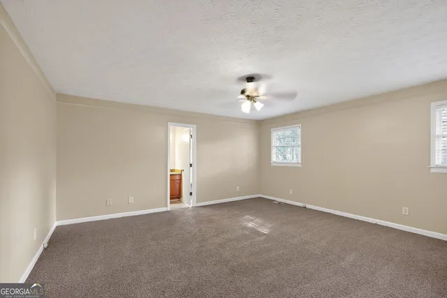 a view of an empty room with a chandelier fan