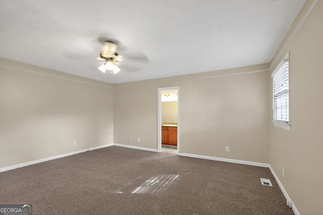 en empty room with windows and ceiling fan