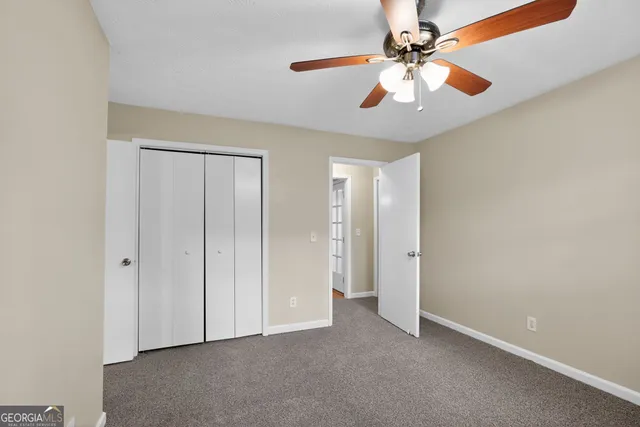 an empty room with fan and entryway