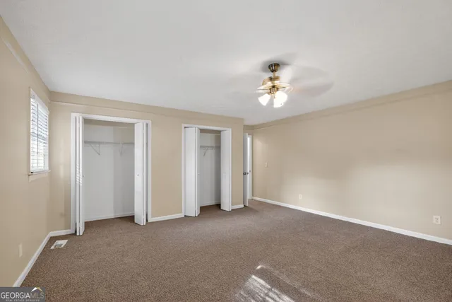 a view of a room with a ceiling fan and a window